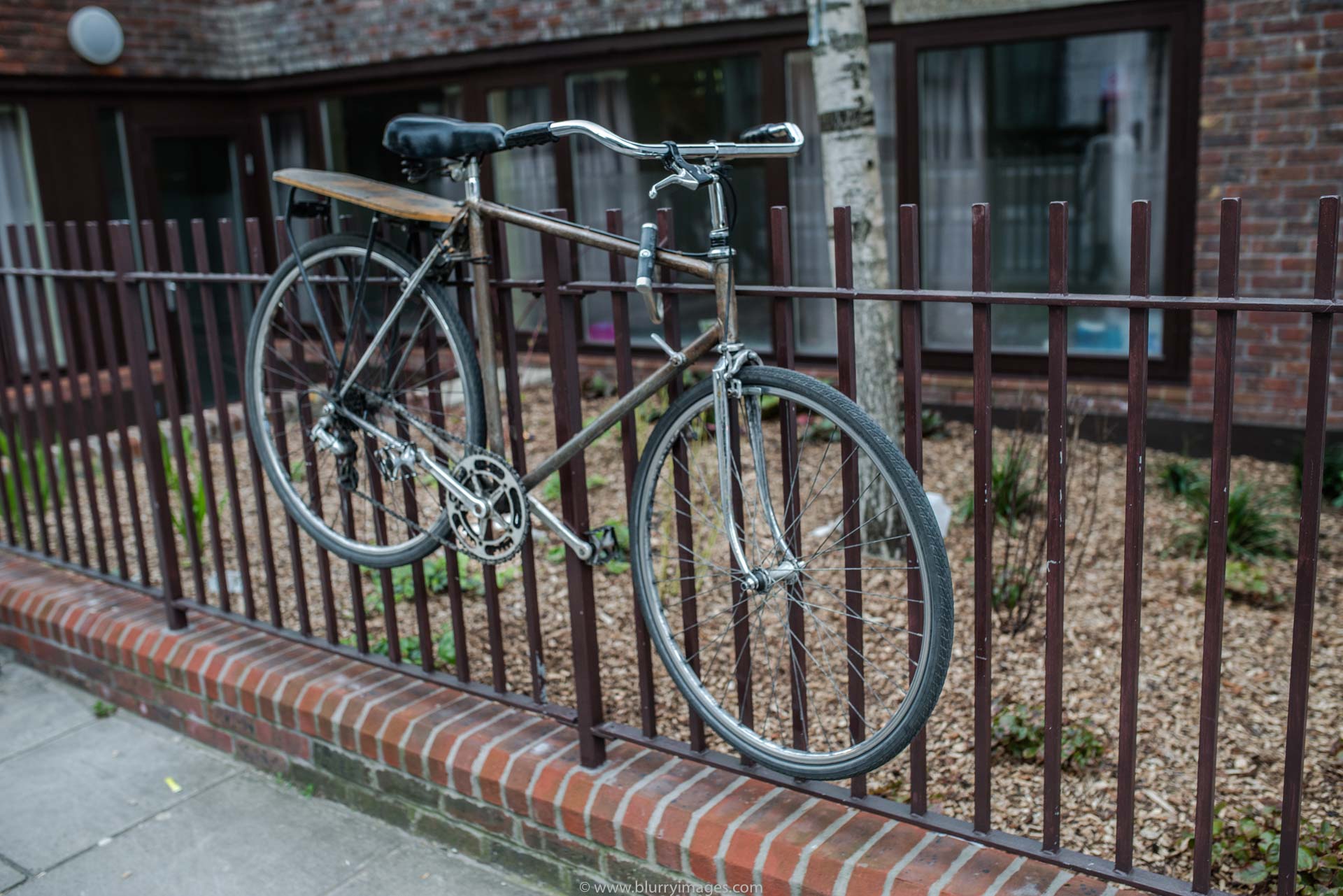 bike, bike chained, fence, brown fence, red bricks, handlebar, outdoors, tree